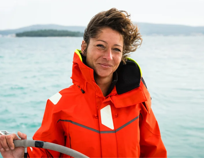 Woman in an orange jacket on a boat