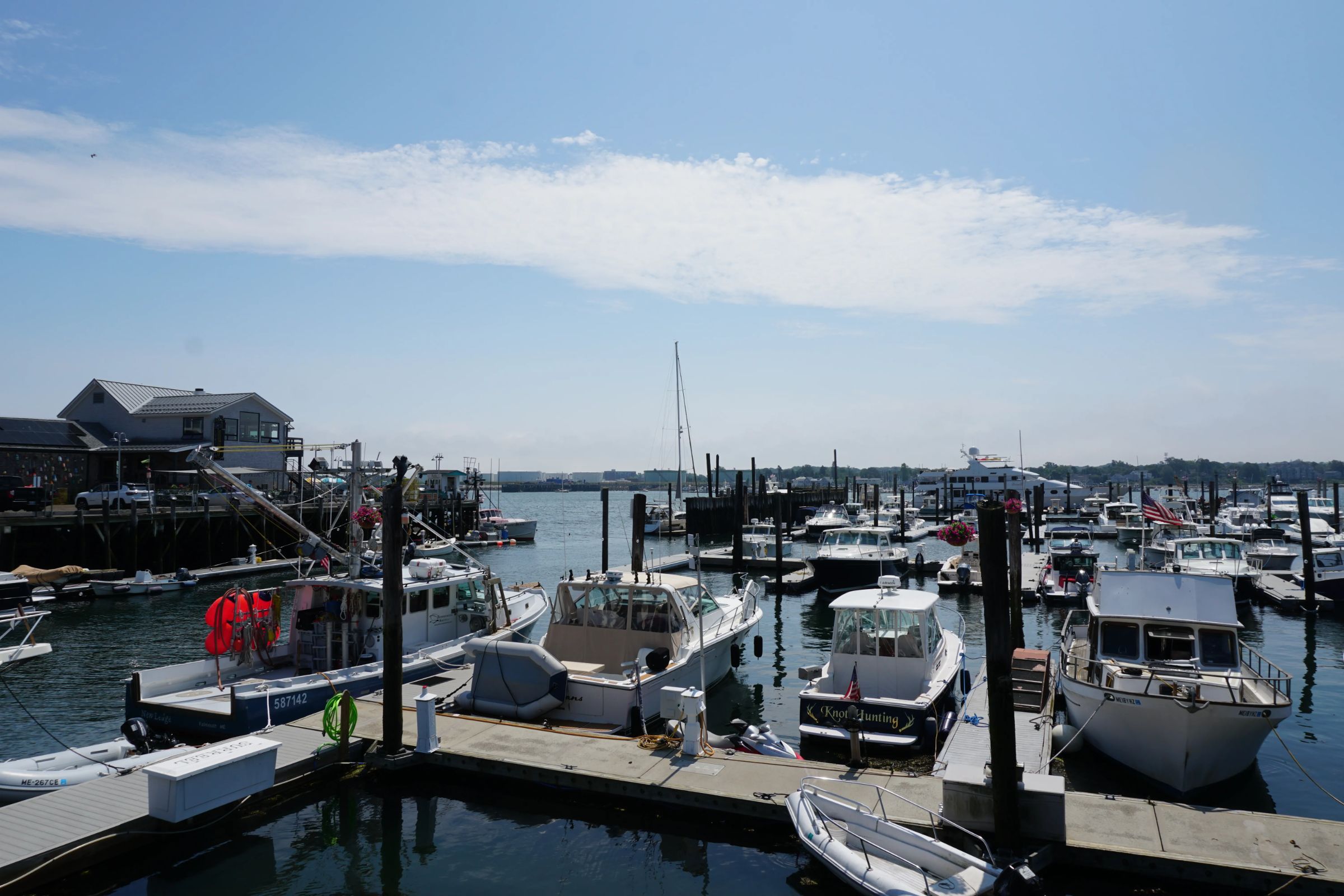 Boats moored at a busy marina on a sunny day