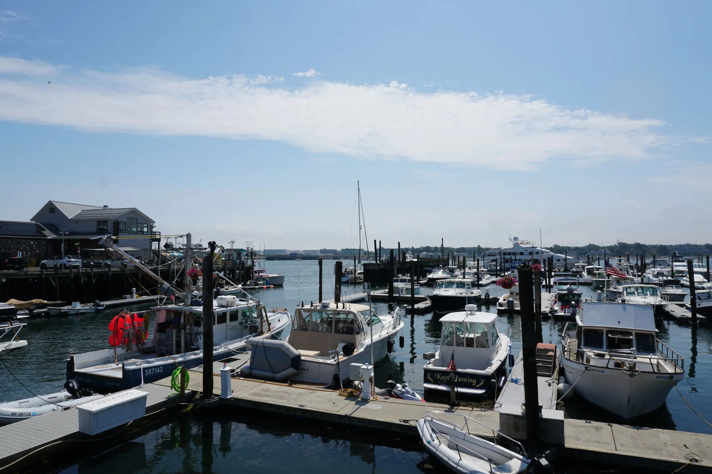 Boats moored at a busy marina on a sunny day