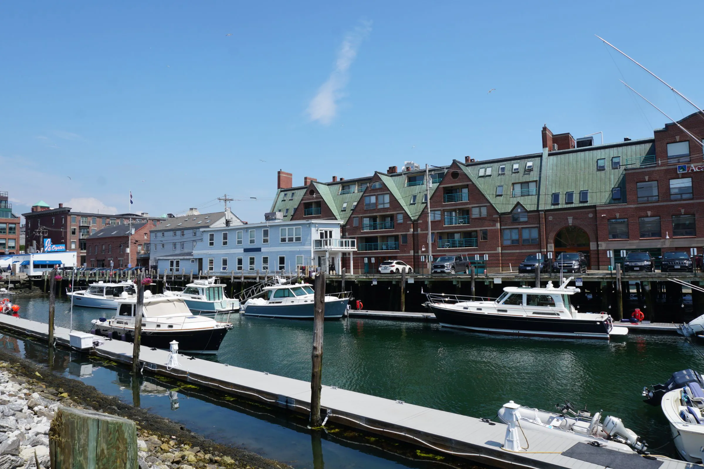 Motor yachts moored at a marina in front of brick waterfront buildings